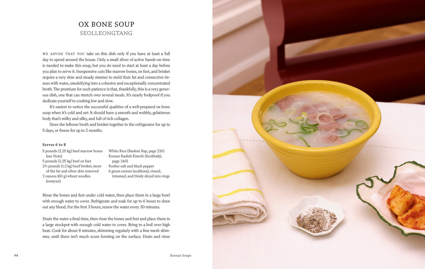 A recipe page for ox bone soup (seolleongtang), a classic of Korean cuisine, features a yellow bowl of soup, side dish, and seasonings on the table next to the recipe text—all inspired by Korean Soups by Clara Lee and Eddo Kim (with signed bookplate!), available from Yu & Me Books.
