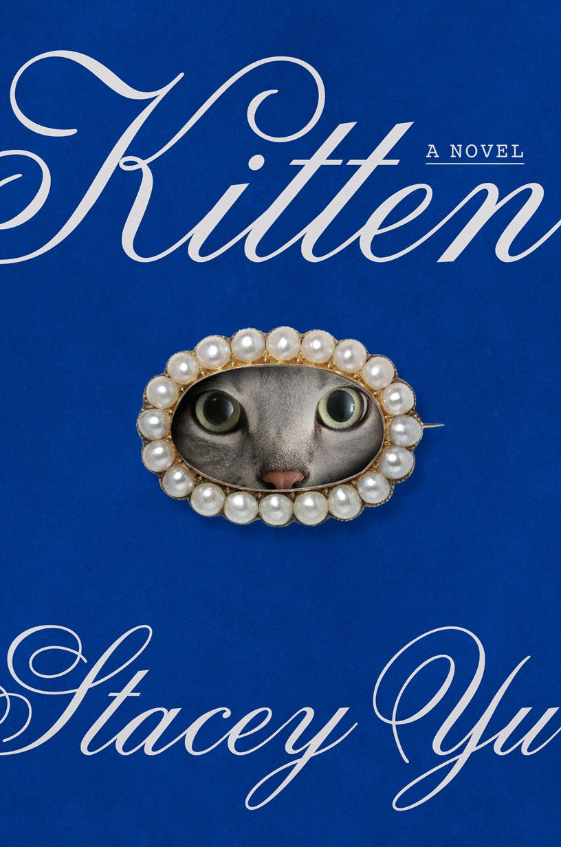 A cat’s face peeks through a pearl brooch on blue for Kitten by Stacey Yu (Signed & Personalized) from Yu & Me Books—pre-order now to reserve your copy of Stacey Yu’s anticipated 2026 debut novel!.