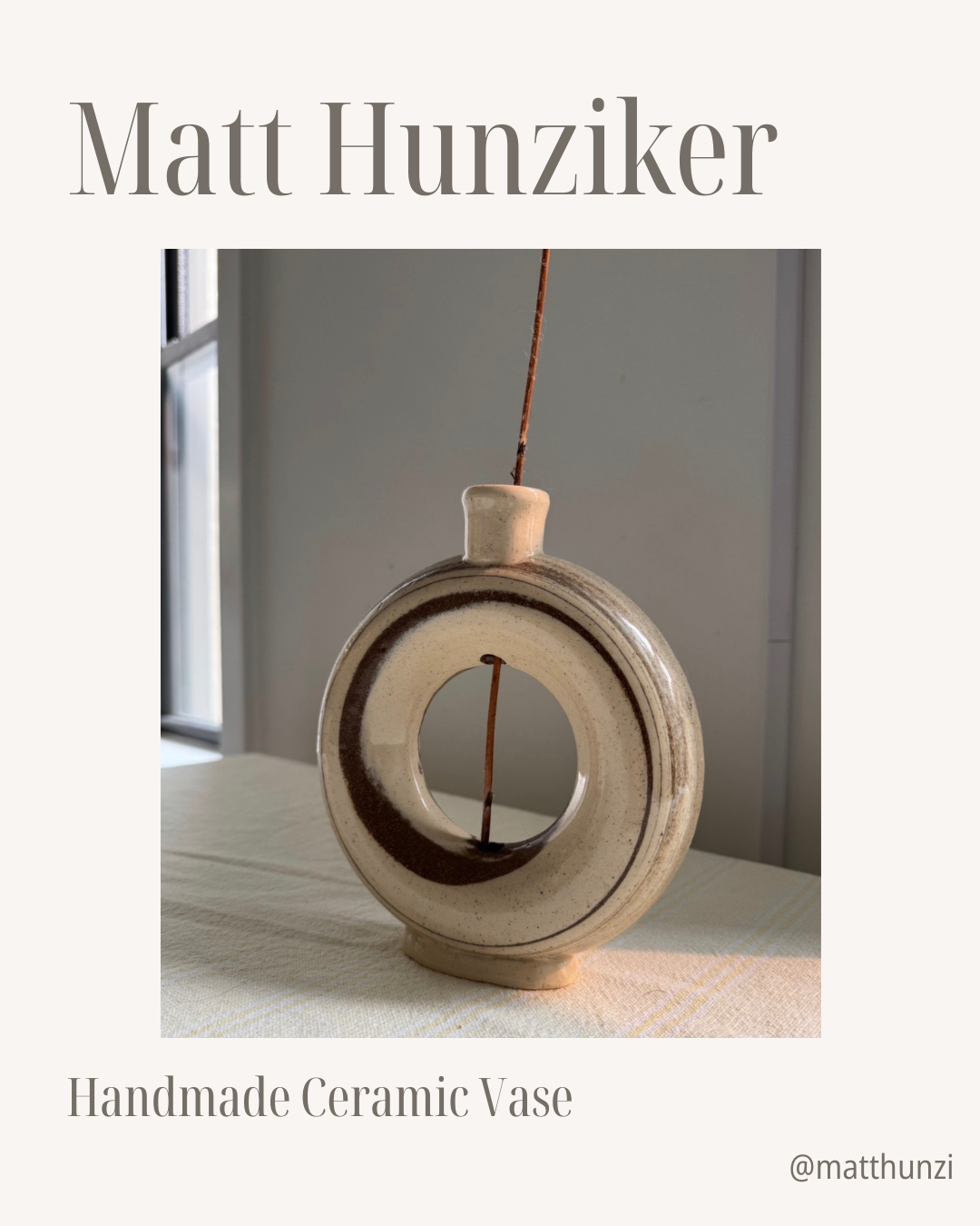 A round, hollow ceramic vase with a small neck, displayed on a table near a window. The vase is beige with a dark brown ring around its center. Reminiscent of the eclectic charm found in your favorite NYC bookstore, it brings a touch of city culture into any space. Text reads: [Raffle] Support Village Works Bookstore! by Yu & Me Books.