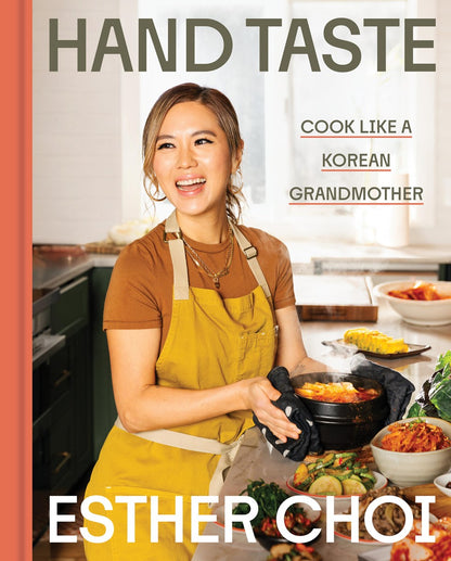 A smiling woman in a yellow apron holds a hot dish in a kitchen, with the text “[Korea Society Event] Hand Taste by Esther Choi” and “Yu & Me Books” overlaid—offering an inviting glimpse into this cherished Korean cookbook by Esther Choi.