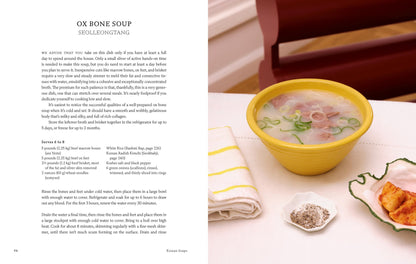 A recipe page for ox bone soup (seolleongtang), a classic of Korean cuisine, features a yellow bowl of soup, side dish, and seasonings on the table next to the recipe text—all inspired by Korean Soups by Clara Lee and Eddo Kim (with signed bookplate!), available from Yu & Me Books.
