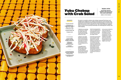 A vibrant plate featuring two tofu pouches filled with rice and crowned with crab salad sits atop a yellow tile surface; inspired by beloved Korean recipes from H-Mart: The Cookbook by Stacey Kwon (with Signed Bookplate!), available from Yu & Me Books, and accompanied by recipe text displayed to the right of the image.