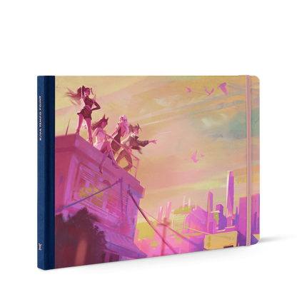 Hardcover K/DA’s Evolution with Art Director Airi Pan travel book with a pink and orange illustrated cover depicting four K/DA characters standing on a rooftop overlooking a city skyline.