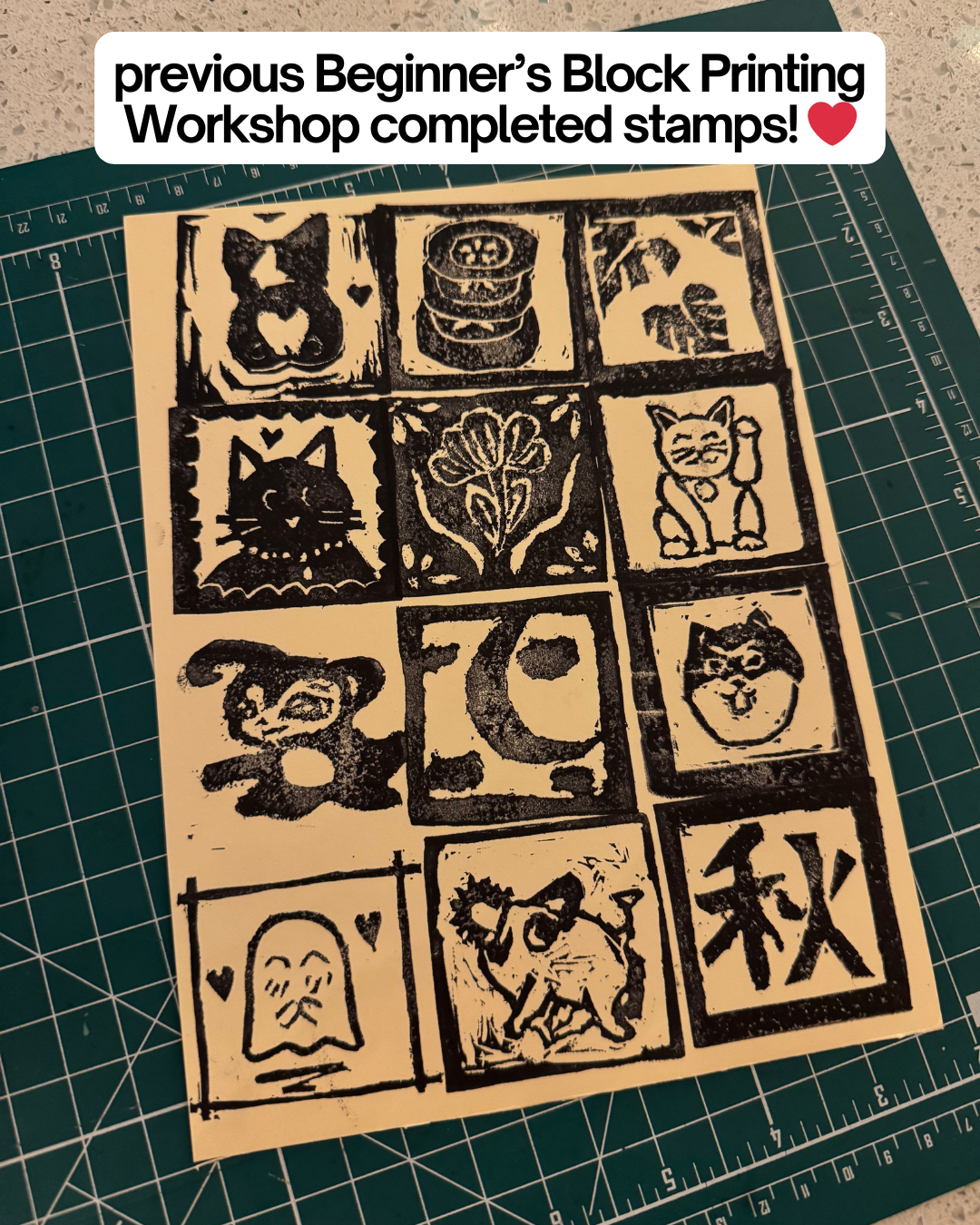 A sheet of cat, flower, and symbol stamps from the Beginner's Block Printing Workshop with Kintsugi Print Studio by Yu & Me Books is displayed on a green cutting mat. Text above reads: previous workshop completed stamps! ❤️.